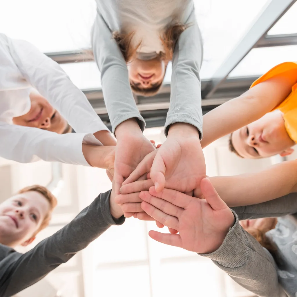 Tineri care își unesc mâinile într-un gest de solidaritate, imagine de pe site-ul Legal Community